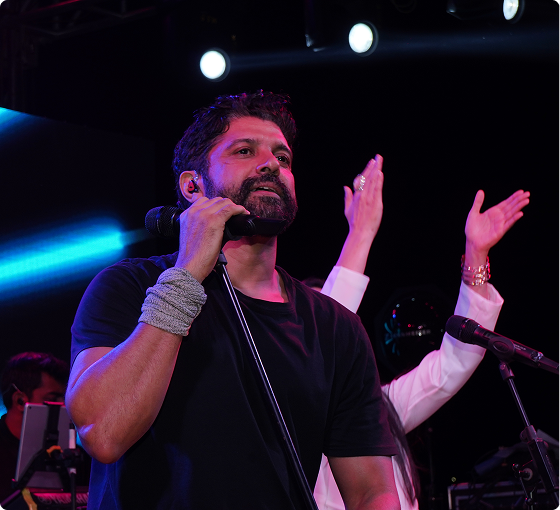 Live concert performer singing on stage under blue lights