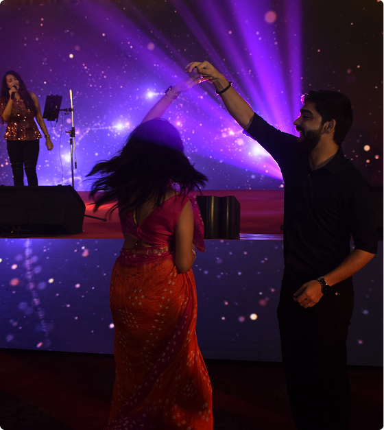 Couple dancing on stage during an evening event under purple lighting