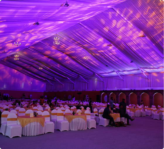 Banquet hall with round dinner tables under purple ambient lighting