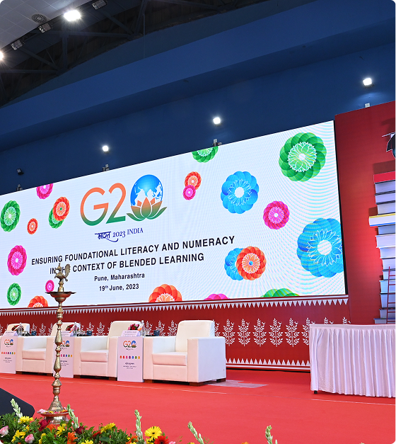 G20 themed conference stage with floral motifs and panel of dignitaries