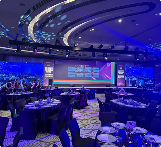 Corporate banquet hall with central LED screen and round tables